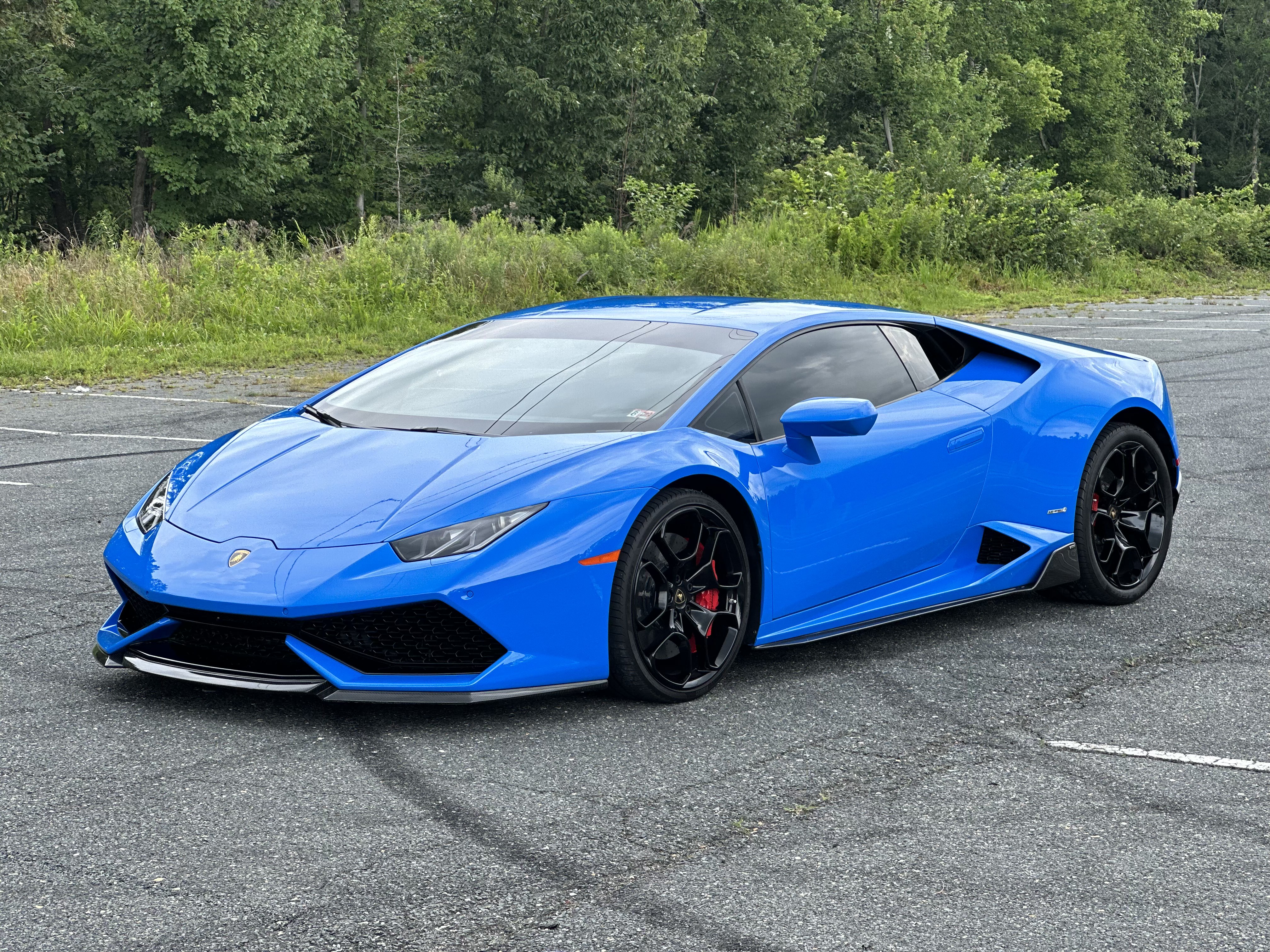 blue 2018 Lamborghini Huracan LP in a parking lot, facing the camera.