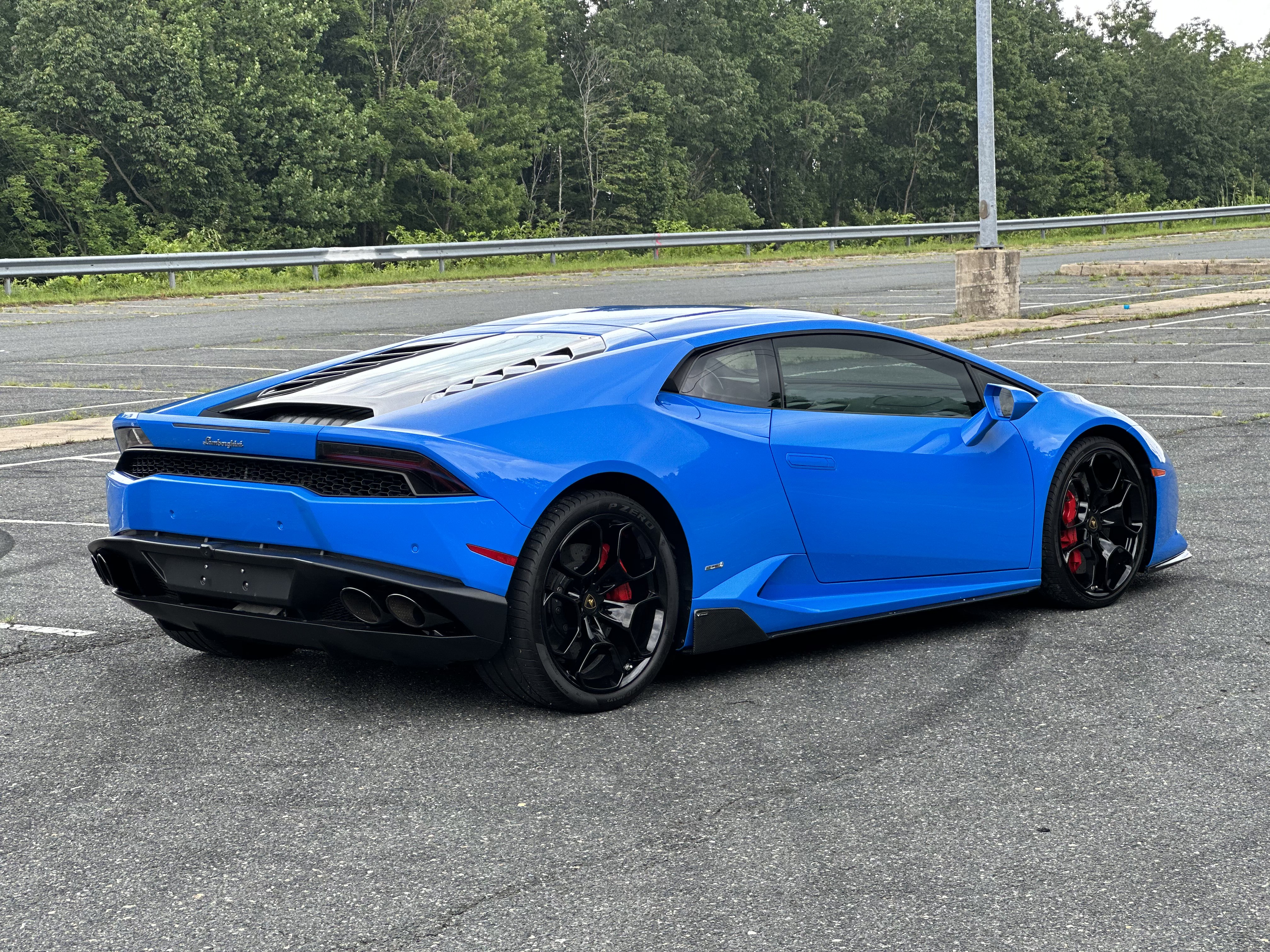 blue 2018 Lamborghini Huracan LP in a parking lot, facing away from the camera